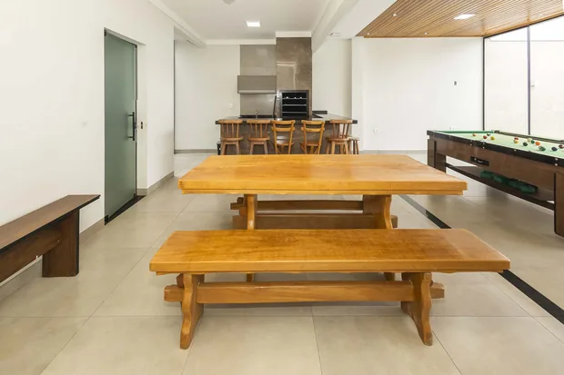 Mesa de madeira maciça com bancos e a sinuca ao lado