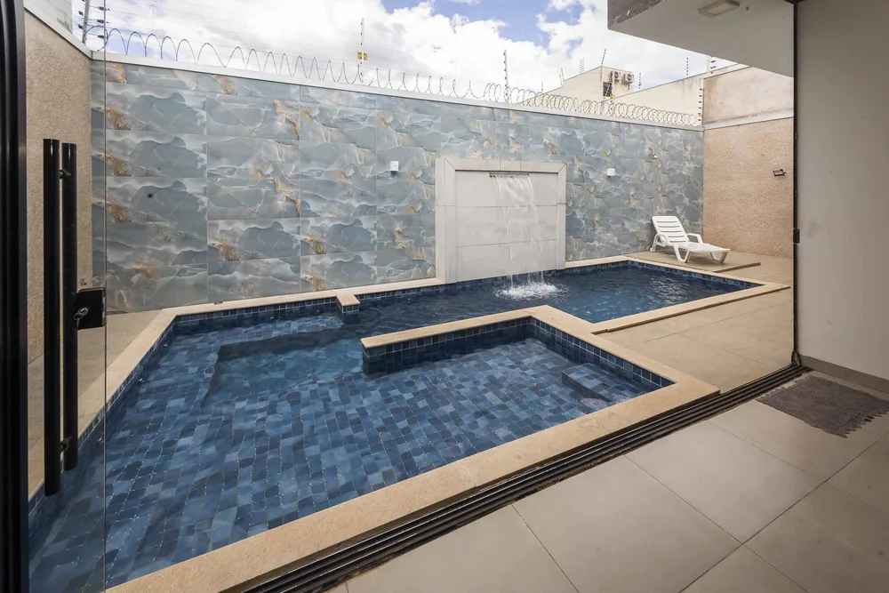 Piscina com a parede de pedra vista de dentro do salão