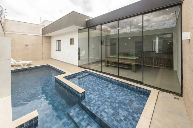 Piscina com a prainha e o salão envidraçado ao lado