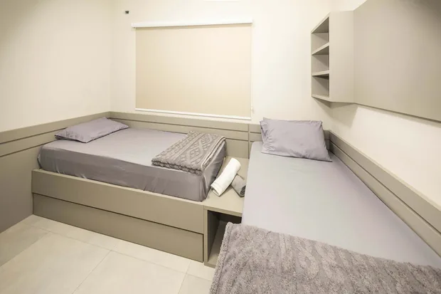 Quarto com duas camas de solteiro e armário planejado