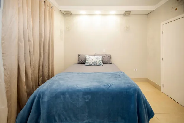Suíte com cama de casal e manta azul